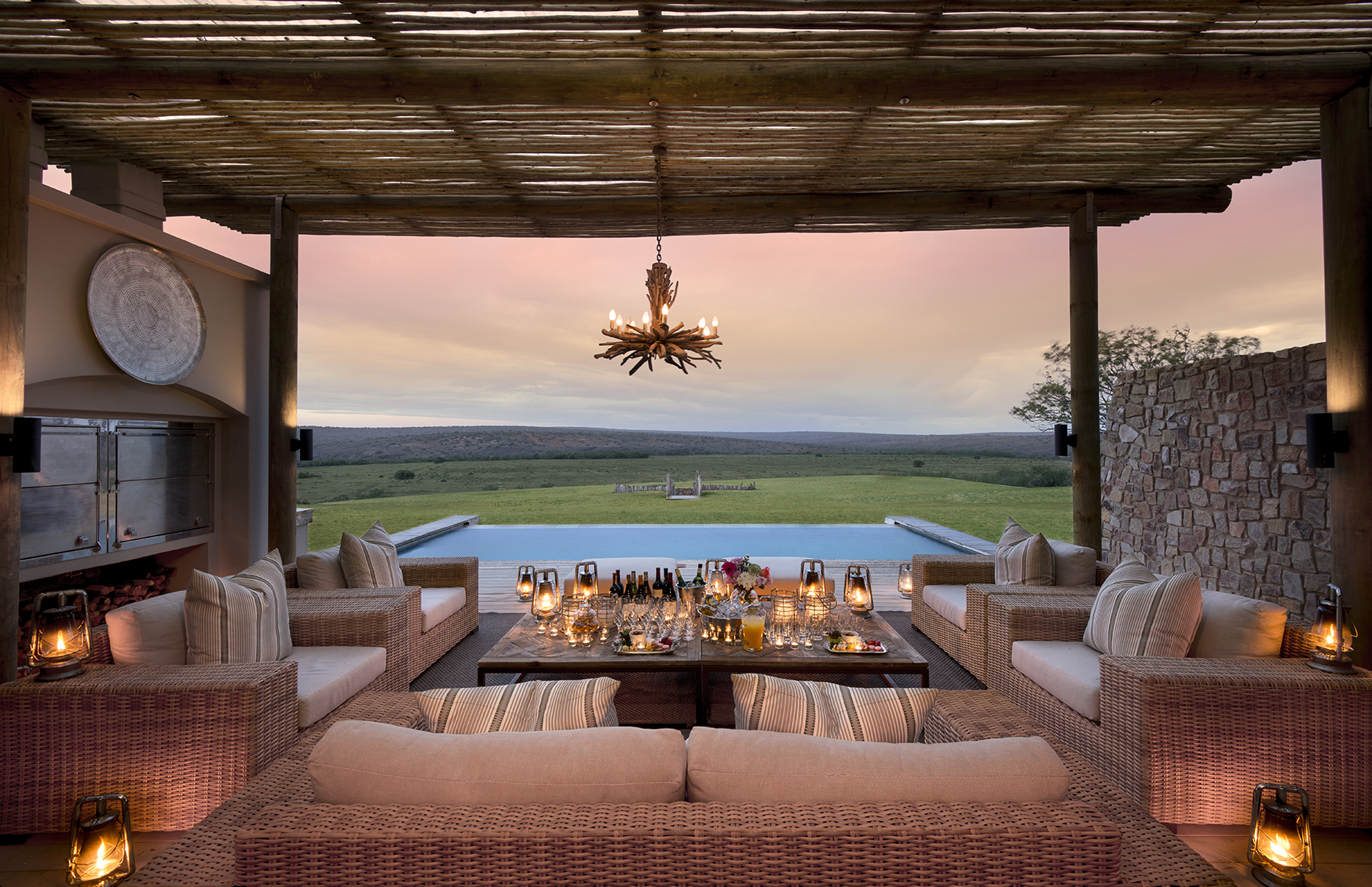 Africa, South Africa, Kwandwe Private Game Reserve Fort House, candle lit poolside seating at sunset