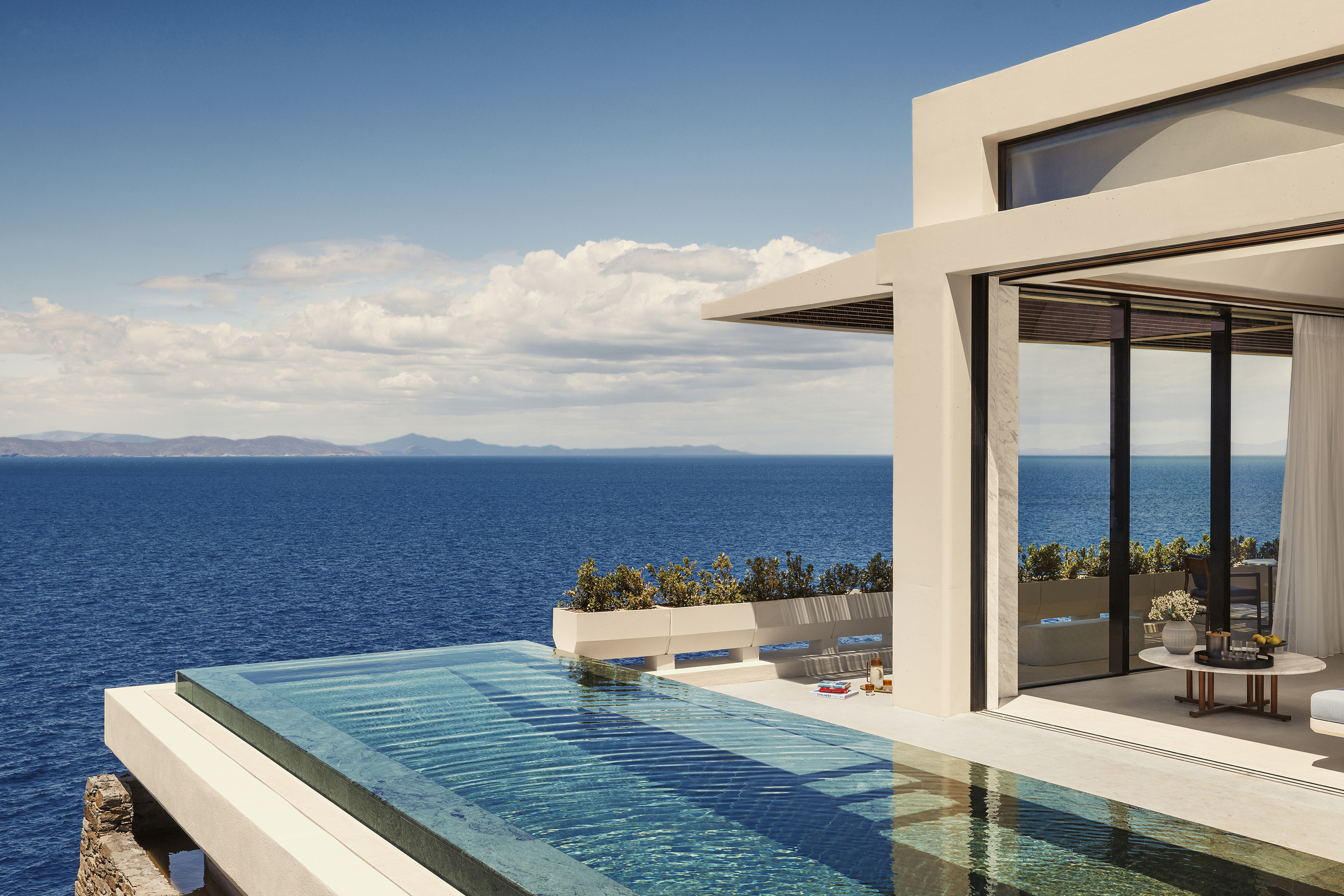 Corner lounge area and pool of Panoramic View Villa with land visible on the horizon