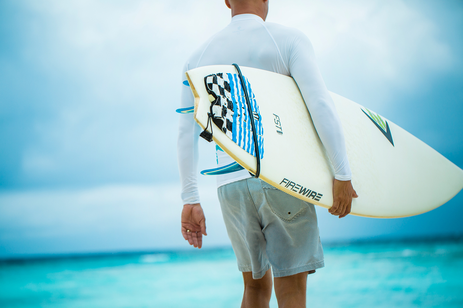 Indian Ocean, Maldives, COMO Maalifushi, Surfer holding board