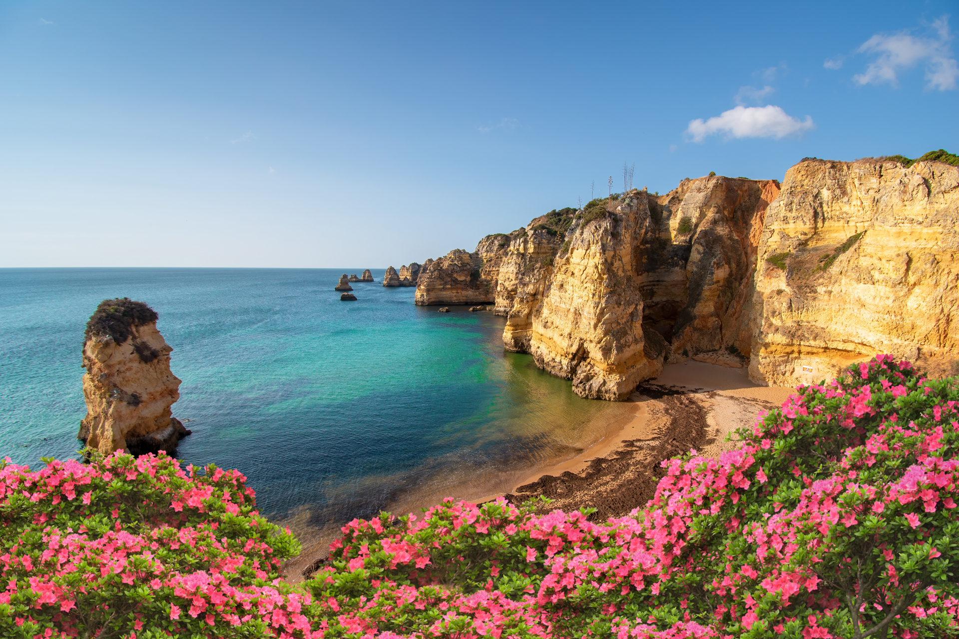 The sun rising in Dona Ana Beach during a queit morning in Lagos, Portugal