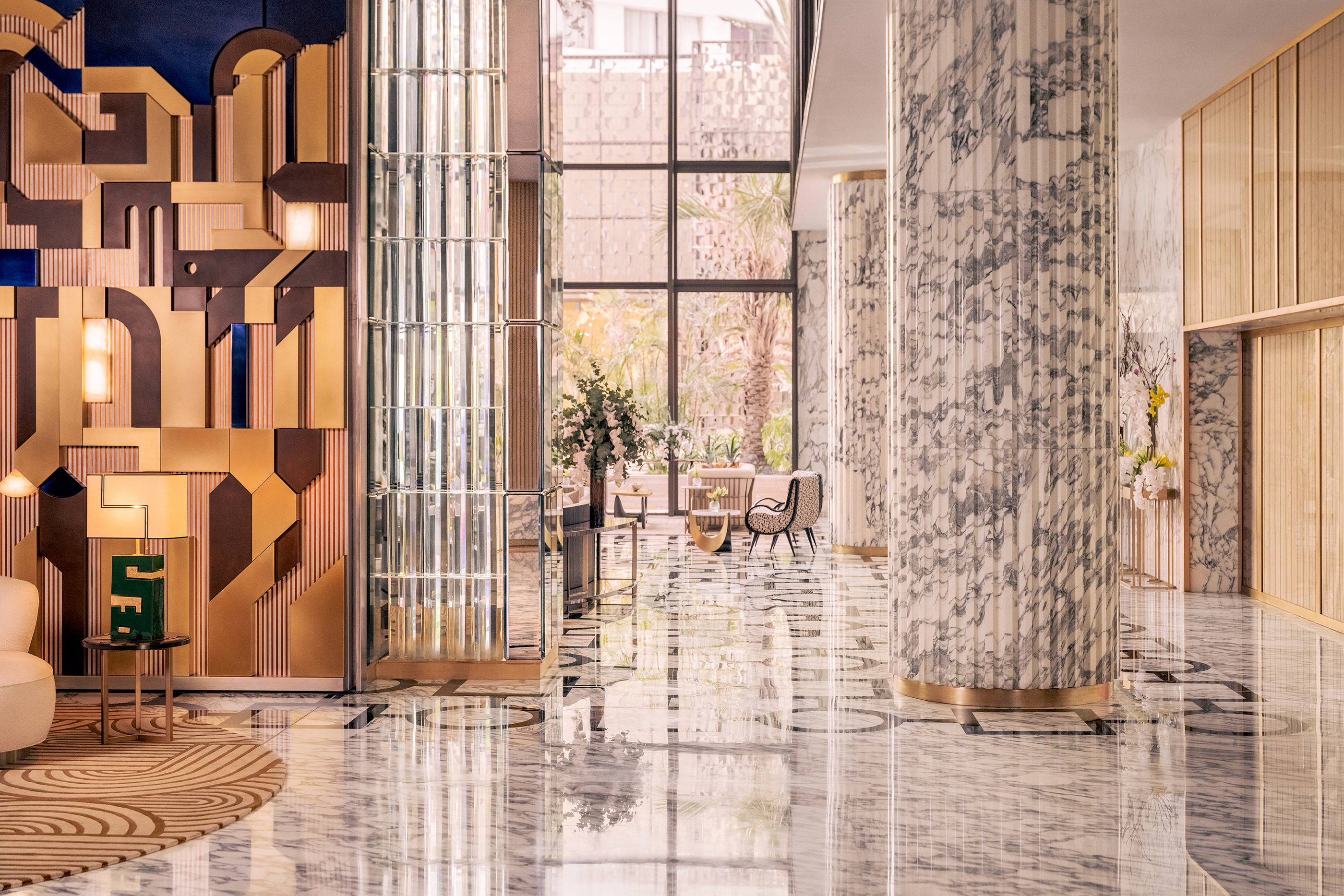 The airy lobby of Royal Mansour Casablanca with marble floor and columns, plush seating and art deco patterned walls