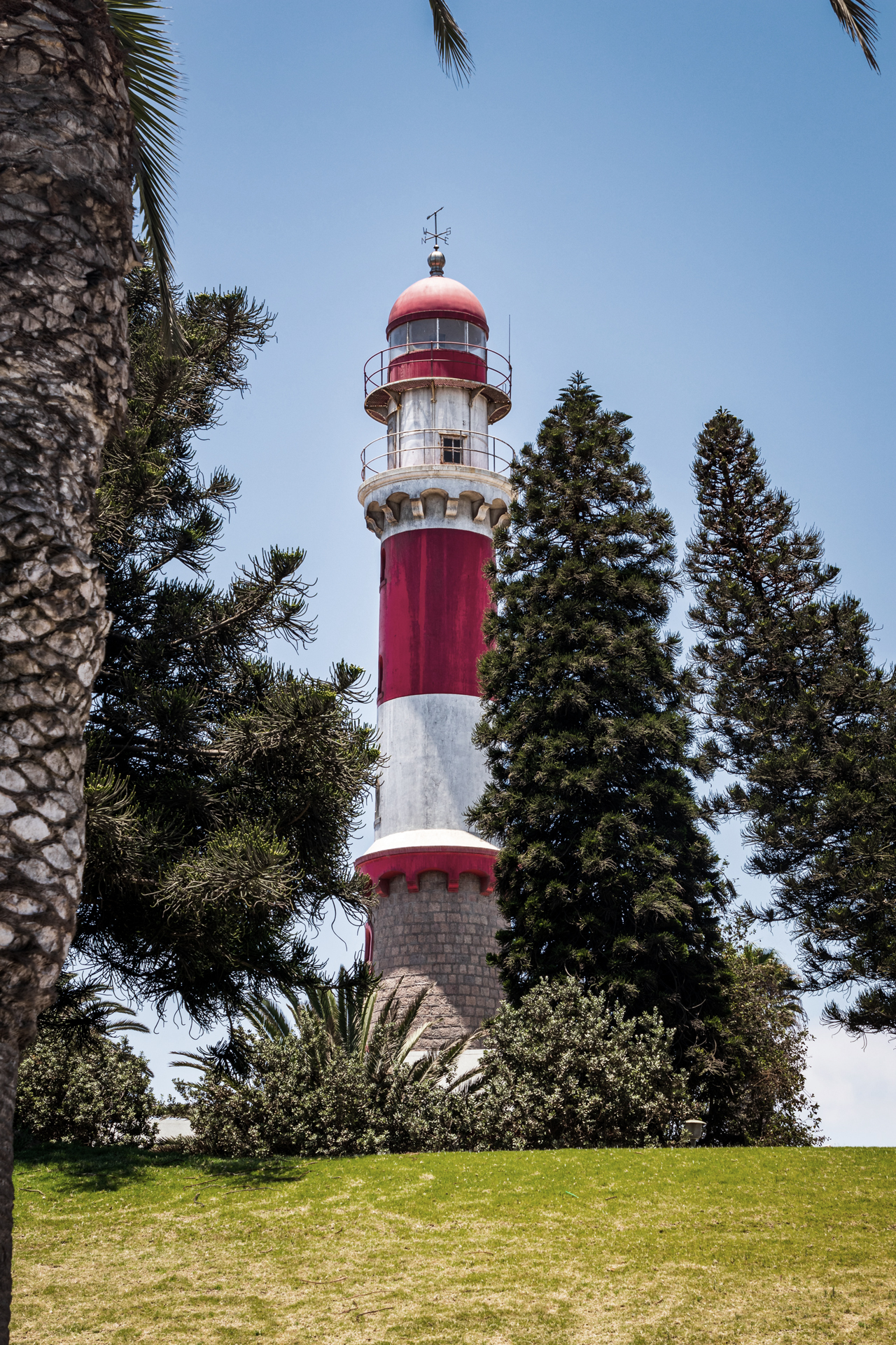 Looking up at an old lighthouse between trees