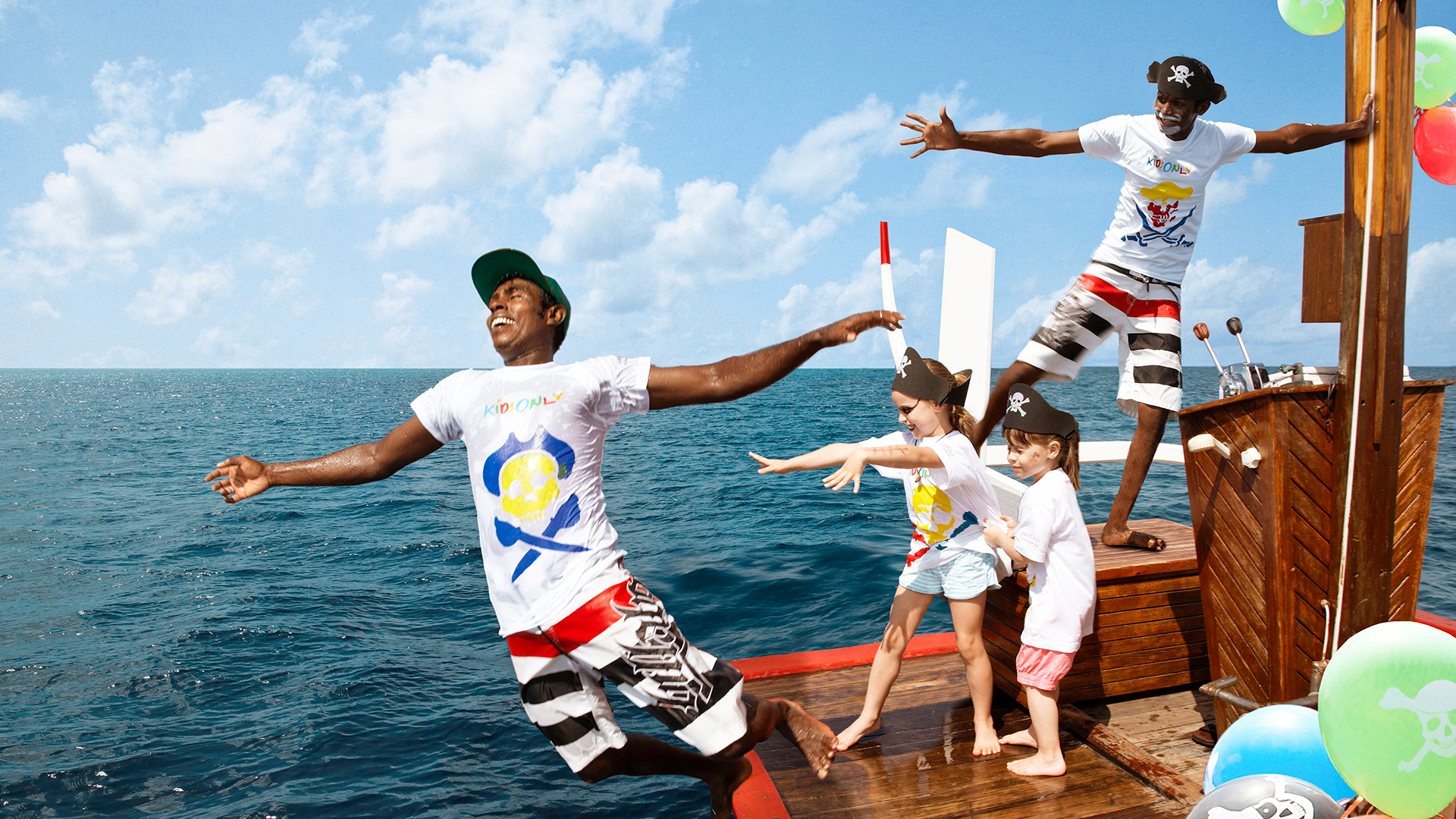 Two children pushing an actor into the water on a pirate cruise at Oneandonly Reethi Rah