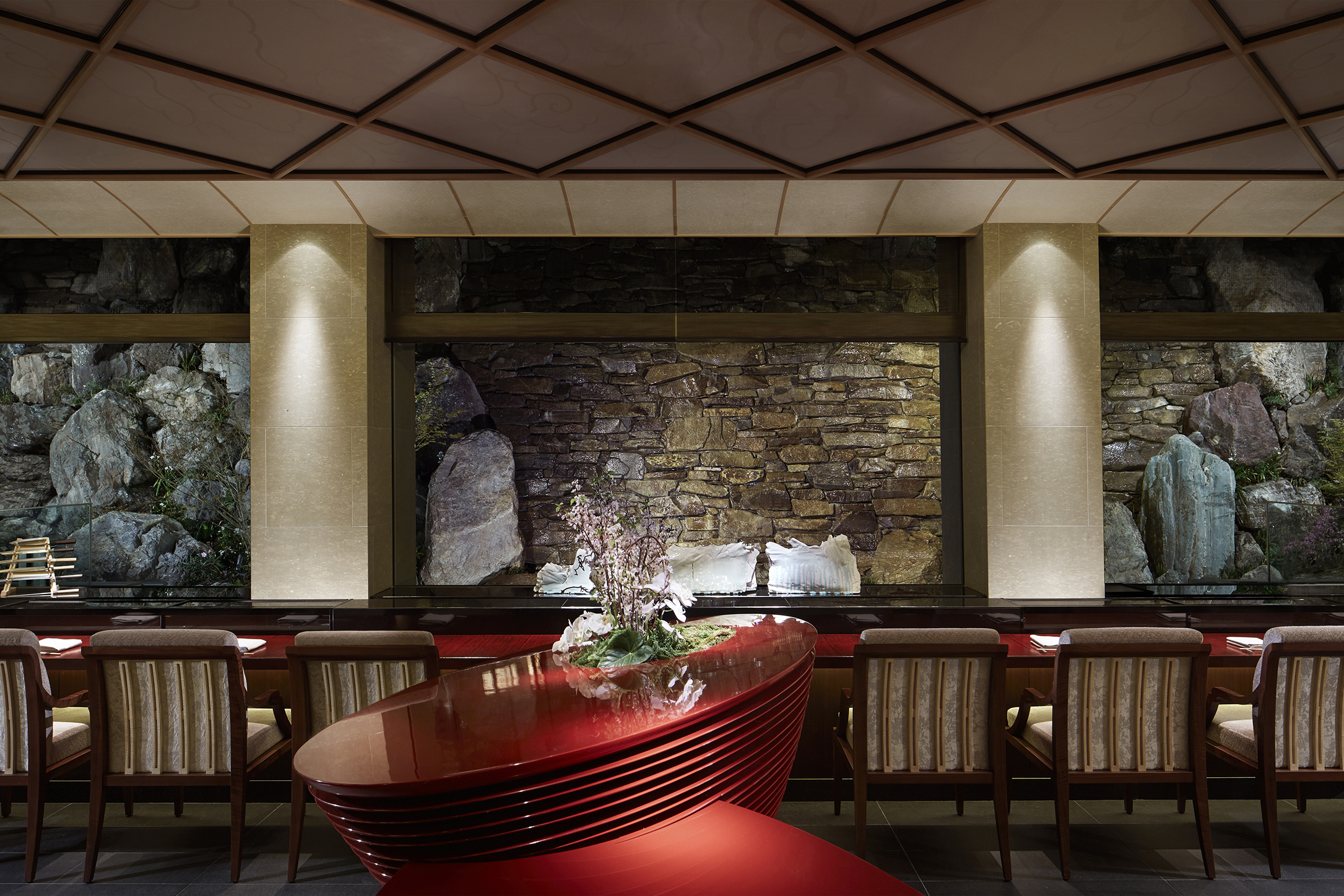 A modern sushi restaurant with decorative red centre piece with flowers