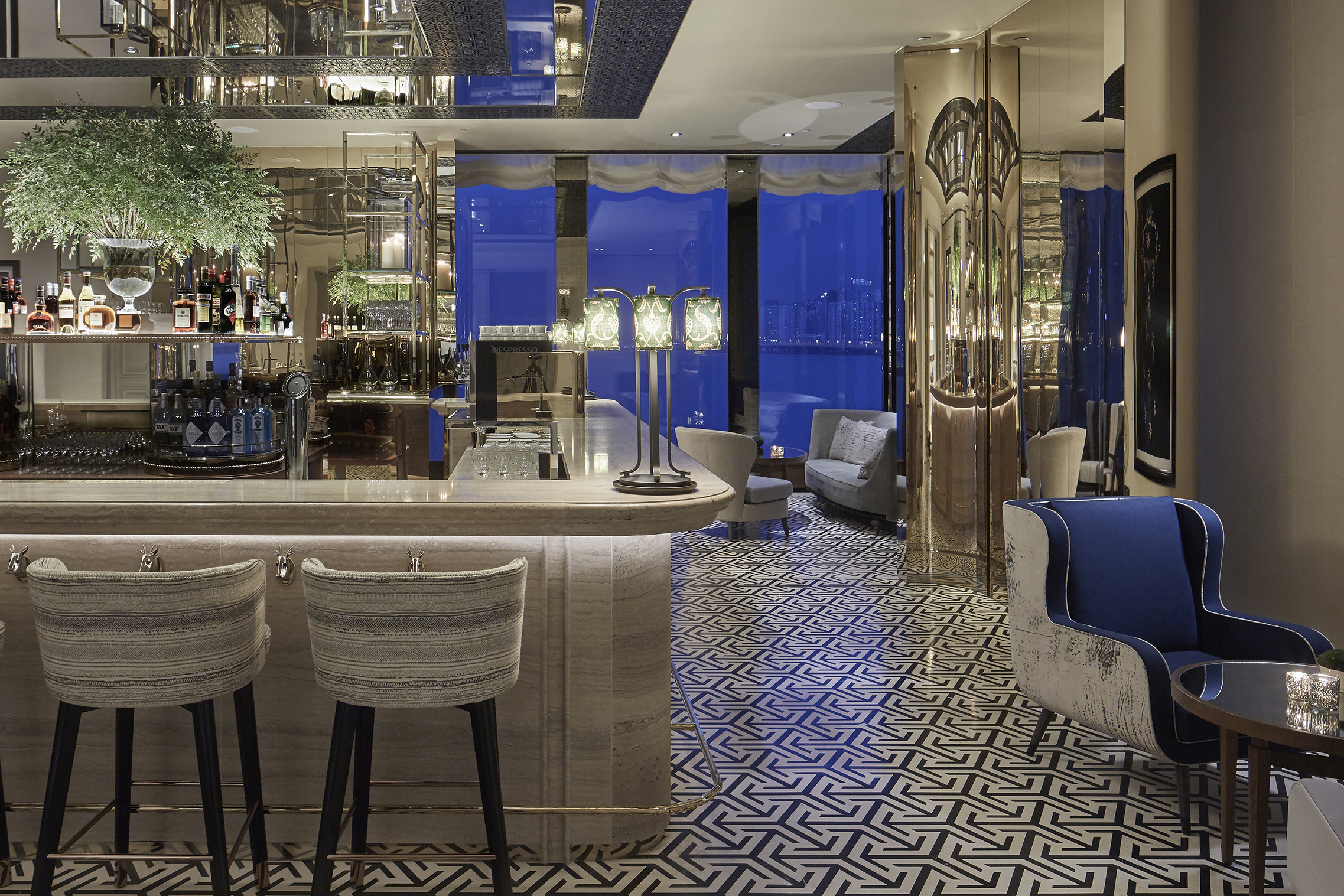 A stylish modern bar in the Rosewood Hong Kong with pale marble accents and geometric patterned floors