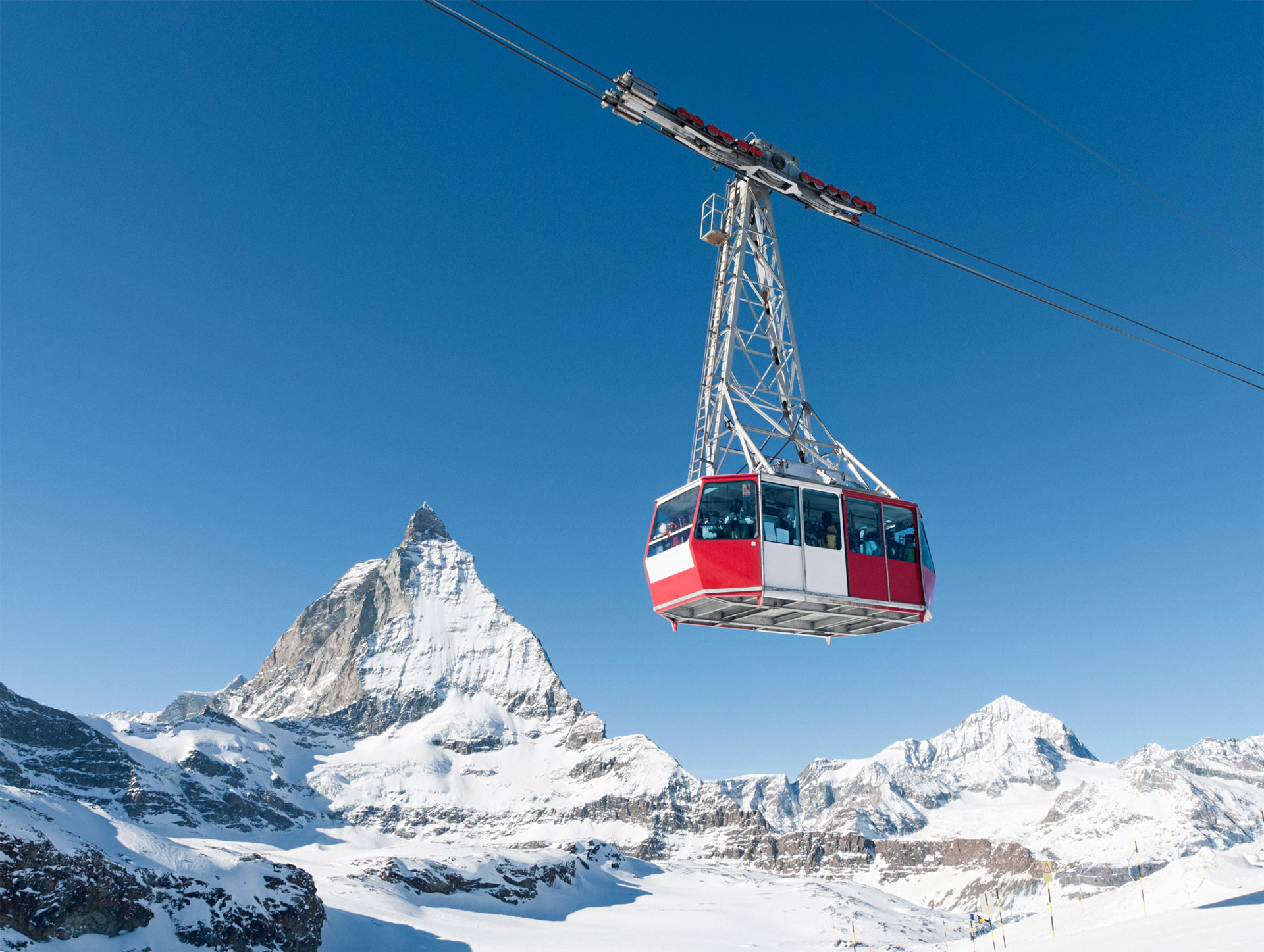 A red and white cable car with the Matterhorn in the background