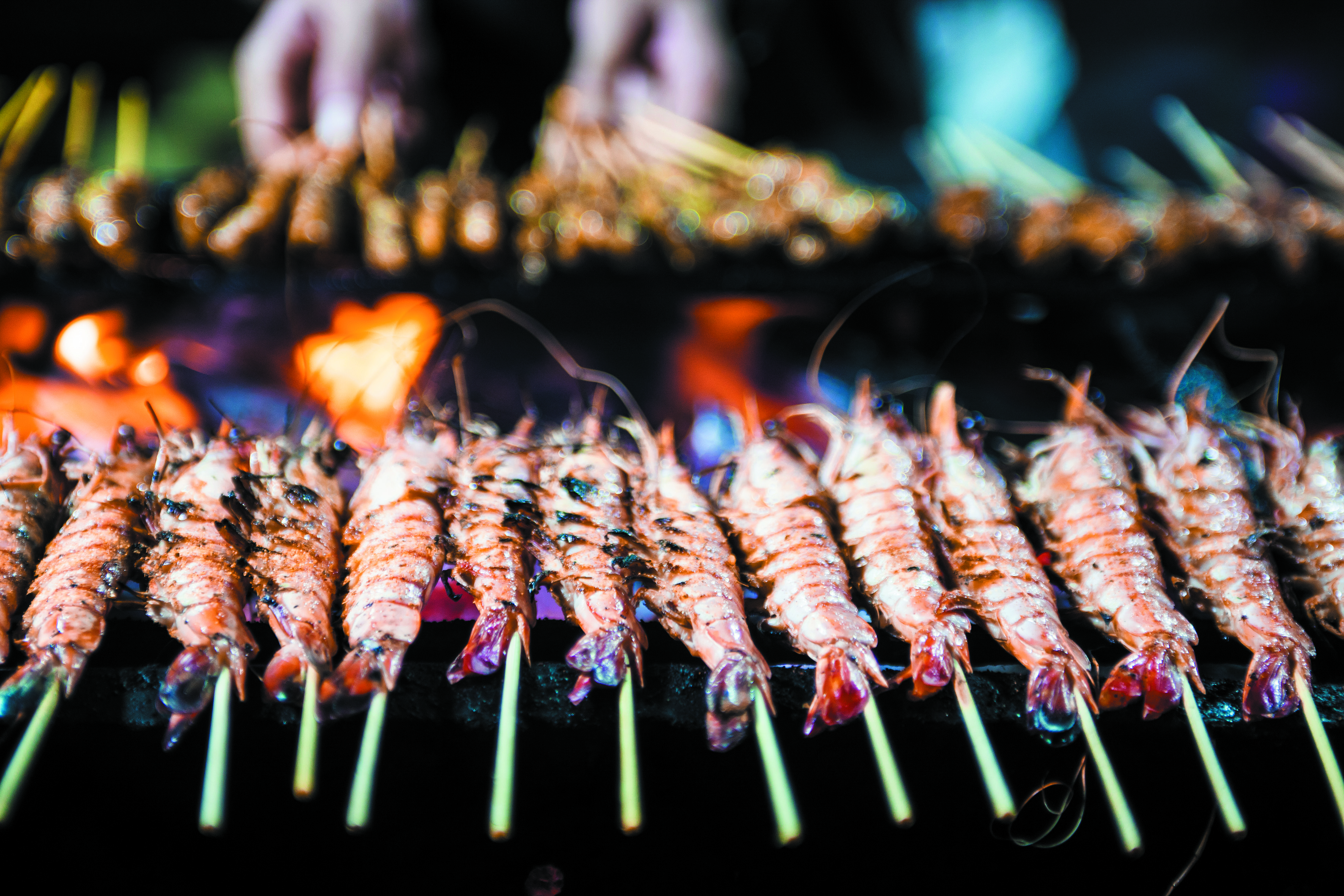 Cooking shrimp satay in Singapore's street food market
