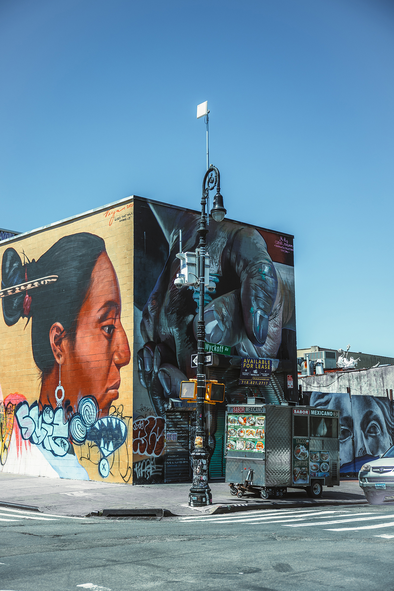 A large mural on the walls of a street corner building in New York