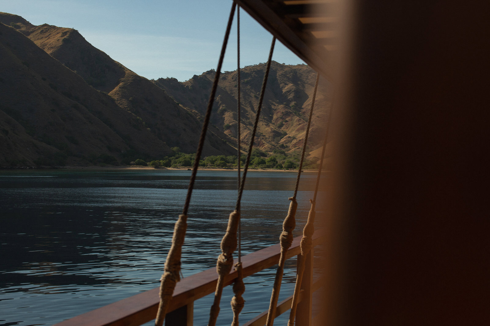 Detail of ropes on a boat anchored near an island